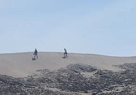 Dos personas atraviensan la duna de Mónsul.