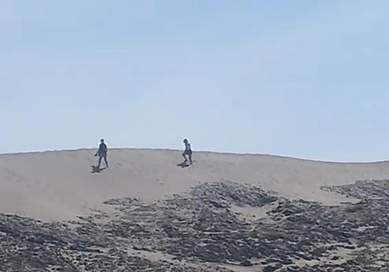 Dos personas atraviensan la duna de Mónsul.