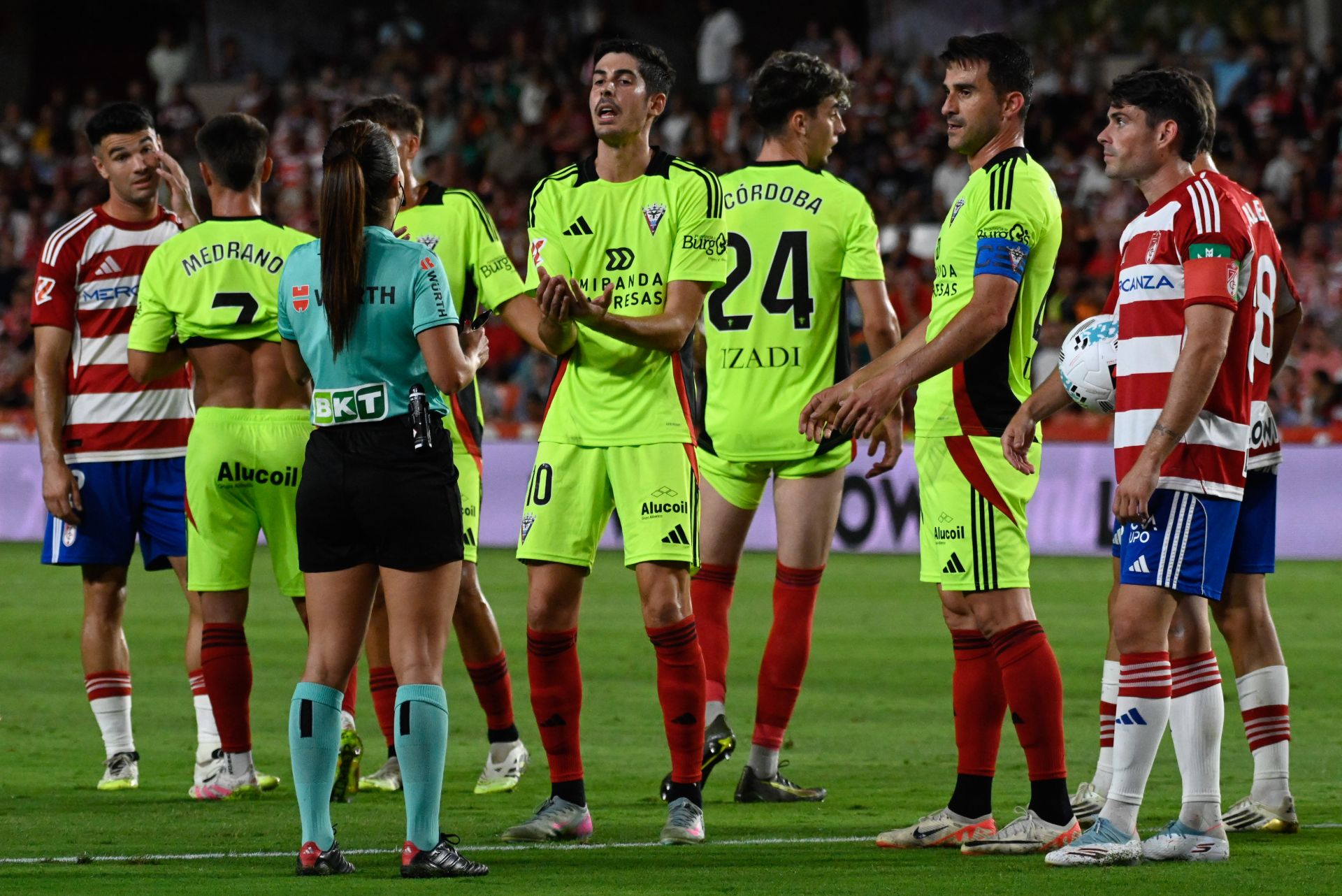 La árbitra Marta Huerta dialoga con los jugadores de Granada y Mirandés durante el partido.