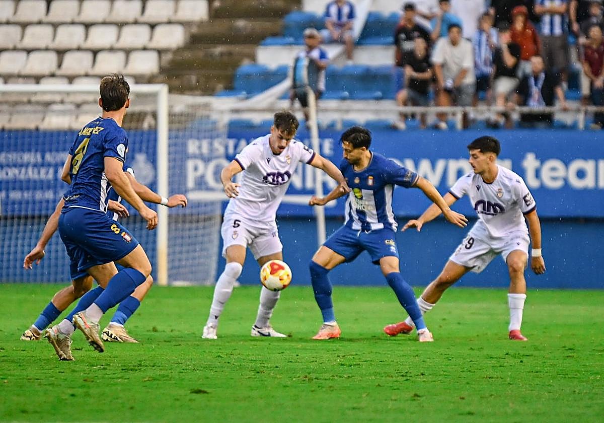 Una acción del partido en la que Del Amo controla el esférico rodeado de adversarios.