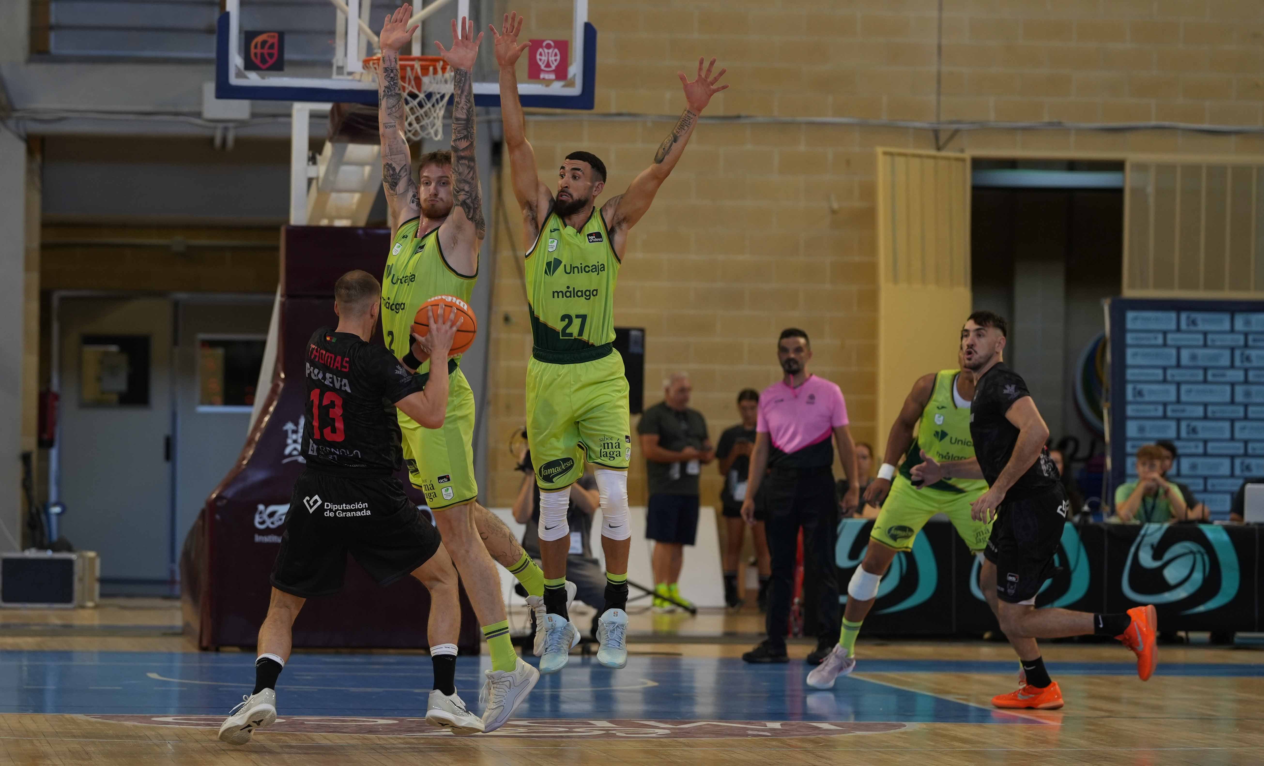 Matt Thomas (13) busca un pase entre la defensa del Unicaja.