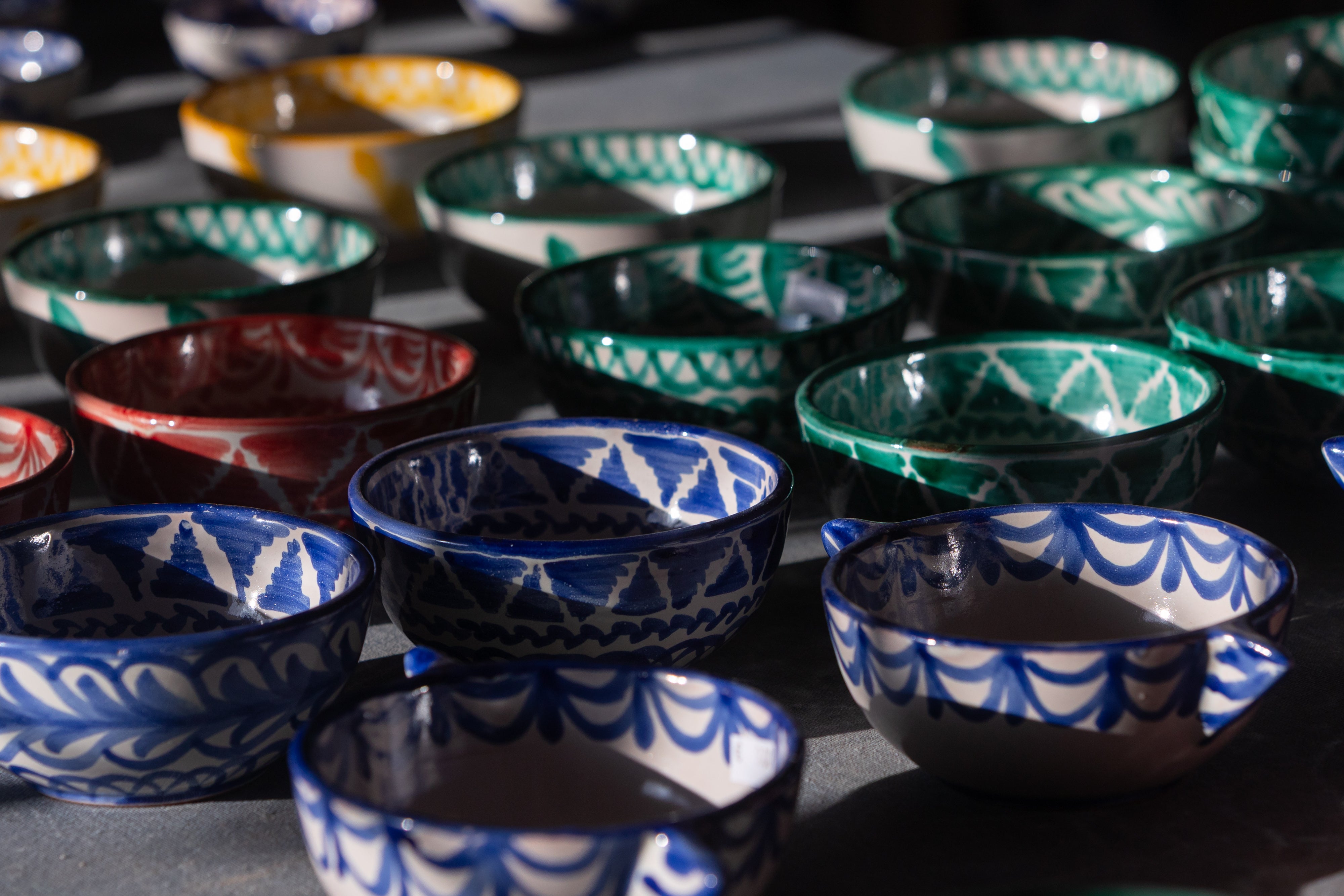 Imagen principal - Manuel España, alfarero de toda la vida, decora un plato. Los lebrillos y los cuencos son los productos más demandados de la fábrica