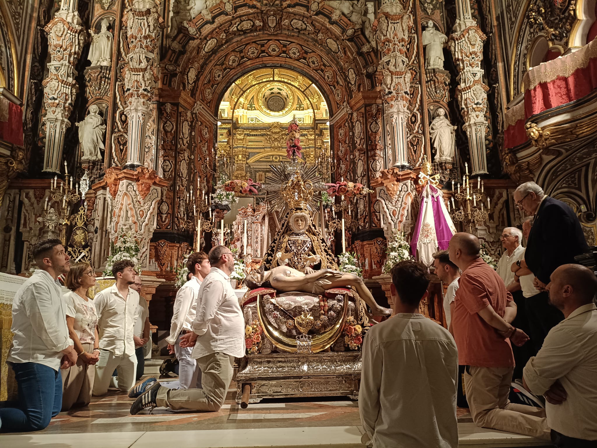 Los miembros de la Hermandad vuelven a unirse en oración tras las palabras que les dirige el Hermano Mayor. Es hora de bajar a la Virgen al crucero de la Basílica para empezar todo el montaje