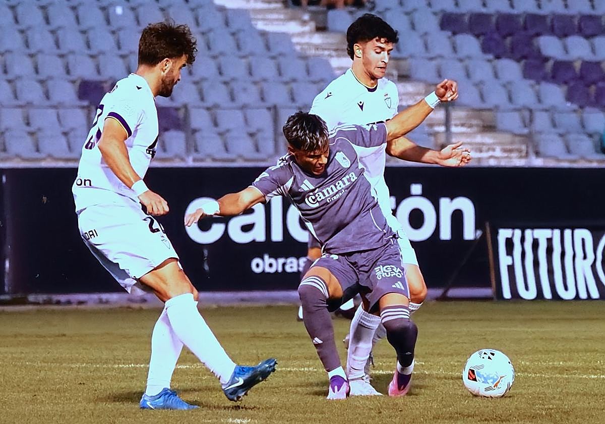 Samu Cortés intenta irse de dos futbolistas del Real Jaén.