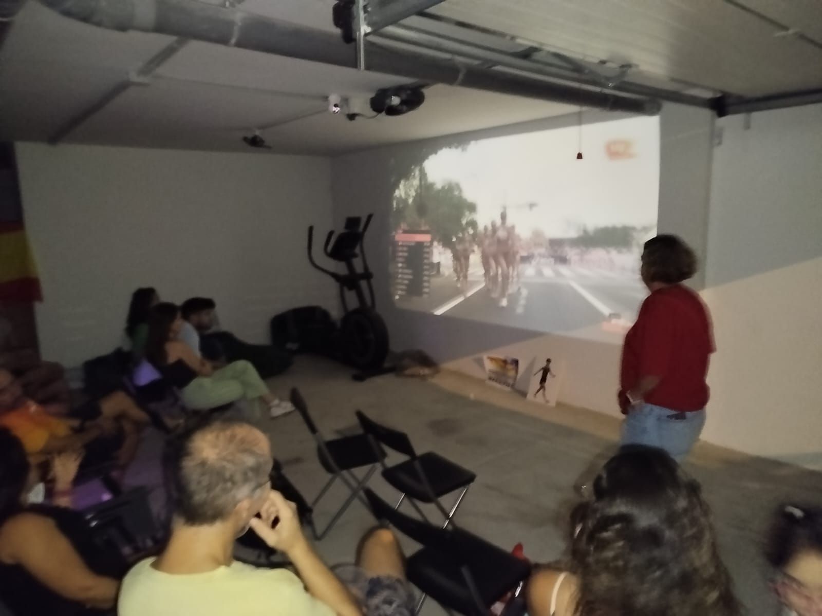Familiares y amigos siguen la carrera con un proyector.