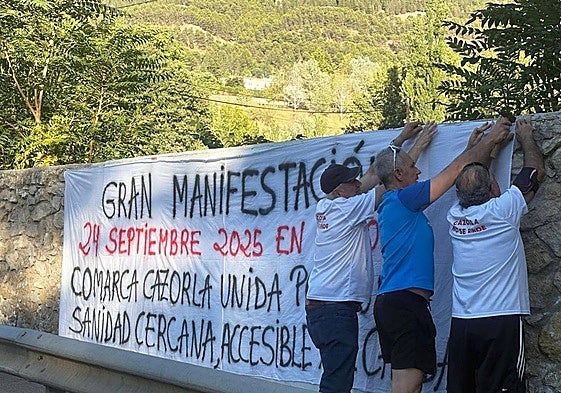 Componentes de la plataforma cuelgan una pancarta a la entrada de Cazorla.