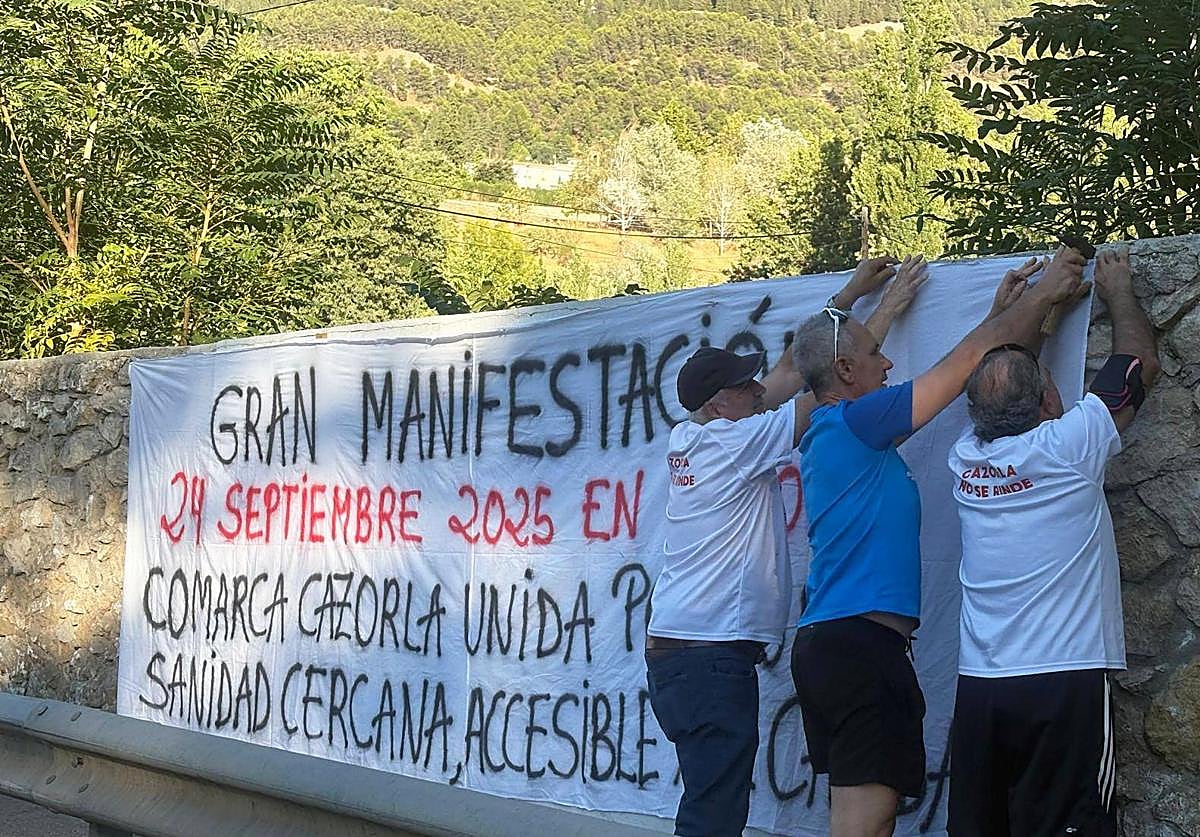 Componentes de la plataforma cuelgan una pancarta a la entrada de Cazorla.