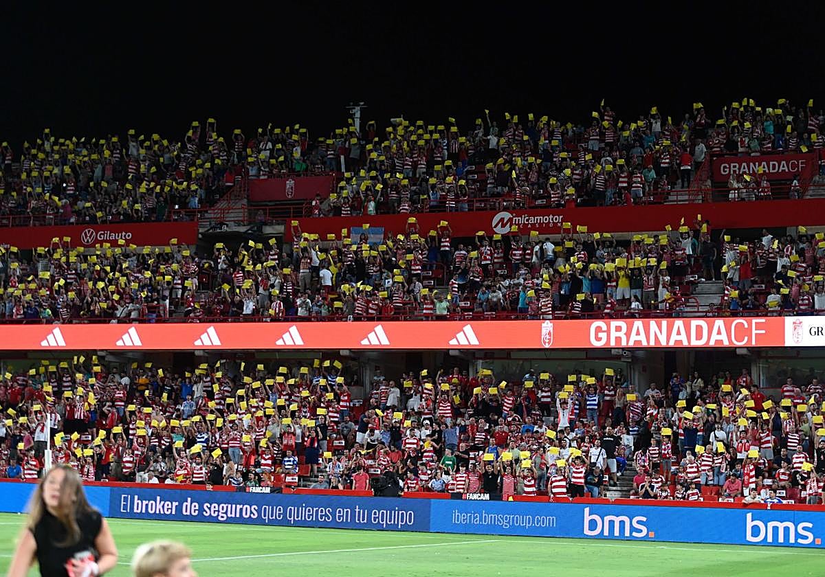 Fondo con aficionados luciendo cartulinas amarillas.