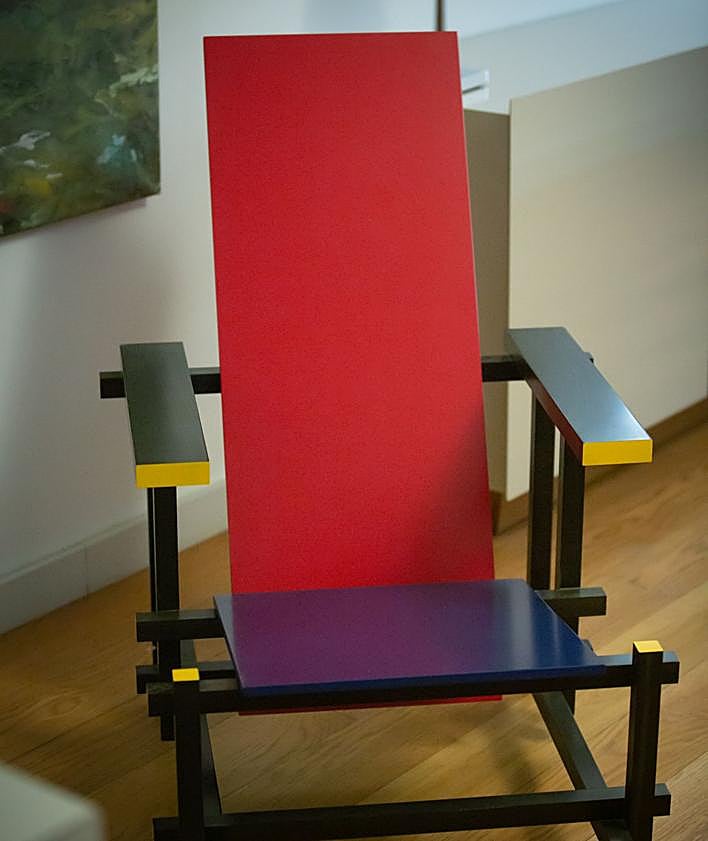 Imagen secundaria 2 - Arriba, libro de Álvaro Siza. Abajo, cristalera con vistas a la Alhambra y sillón de Gerrit Thomas Rietvel. 