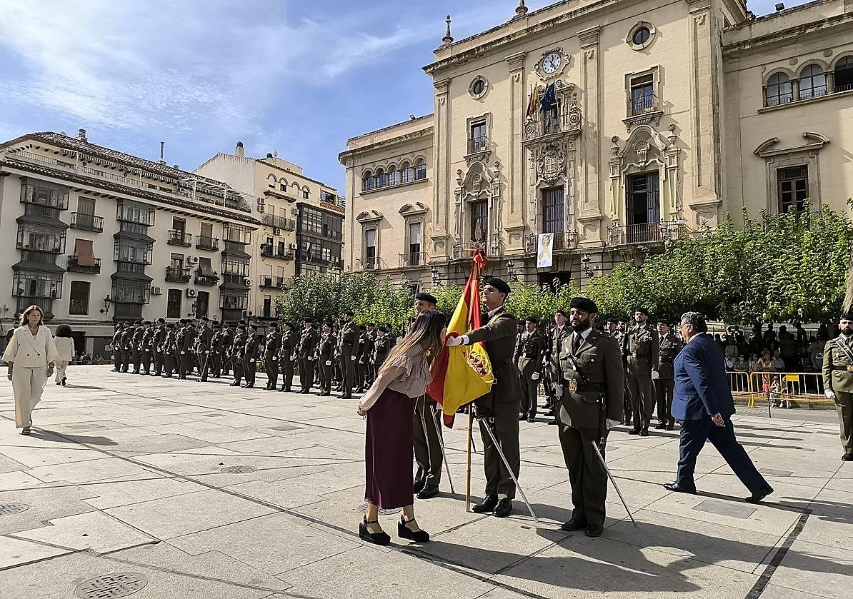 Mujer besa la bandera nacional.