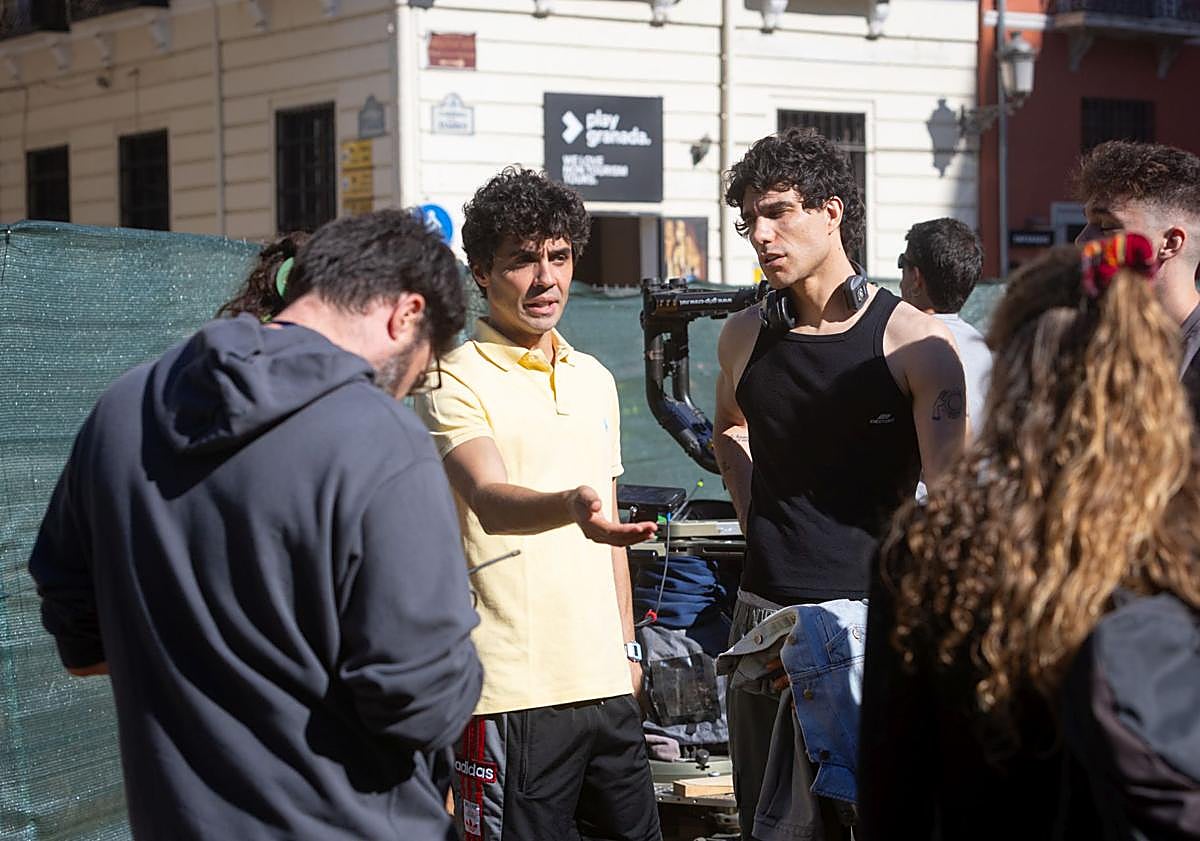 Imagen principal - Javier Ambrossi y Javier Calvo, con miembros del equipo; llegada de figurantes; y Calvo, saludando a los curiosos de la terraza. 
