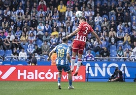 Álex Muñoz cabeceando un balón ante la mirada de Luismi Cruiz