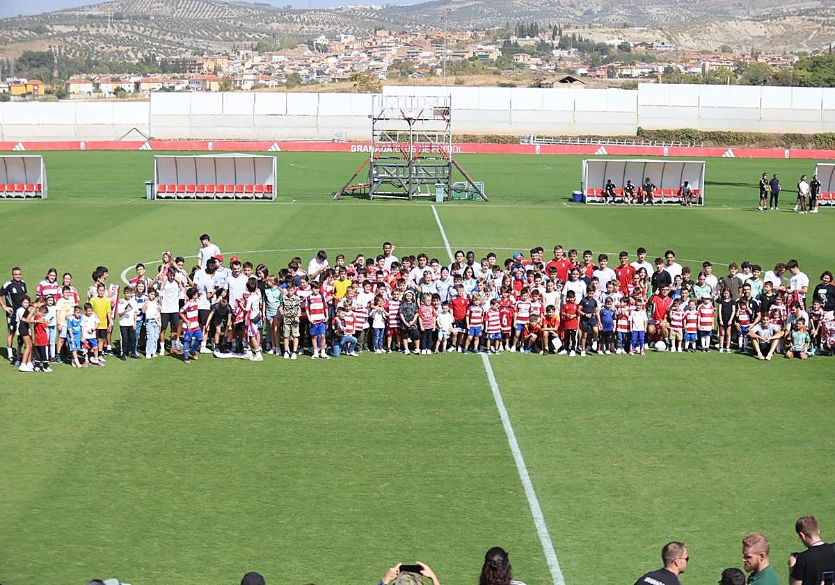 Imagen principal - Arriba, posado de los más pequeños mezclados con el equipo. Debajo, Pablo Saénz firma una bandera a la izquierda y Samu Cortés posa para una foto a la derecha. 