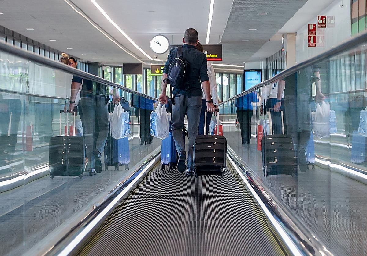 Un viajero, con sus equipaje de mano en un aeropuerto español.