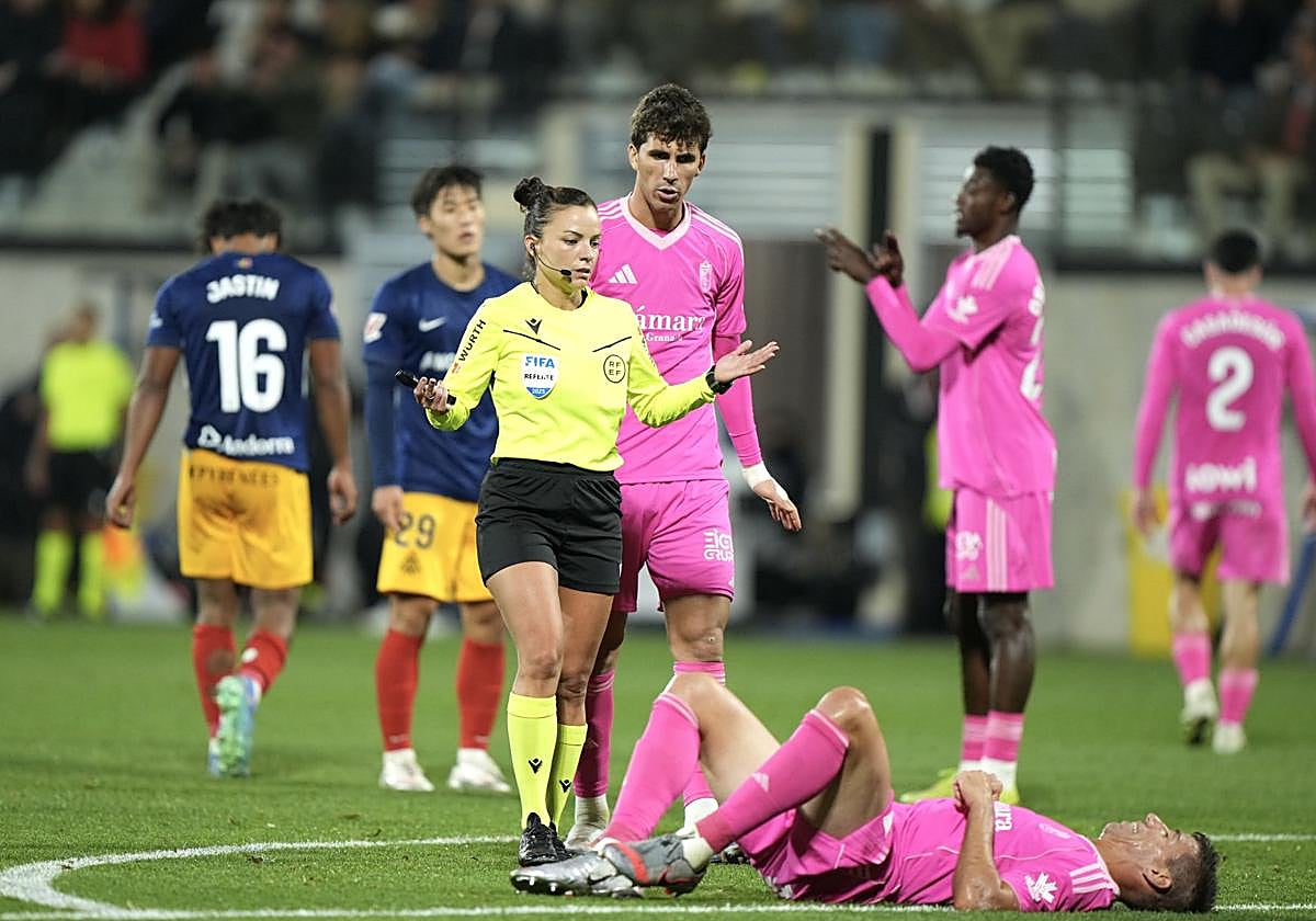 La colegiada Marta Huerta se interesa por un dolido Alcaraz sobre el césped.