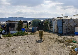 Una persona camina por el asentamiento del Cortijo El Uno de San Isidro, en Níjar.