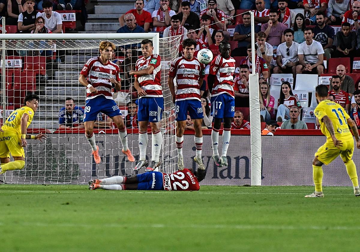 Los jugadores del Granada saltan en una barrera.