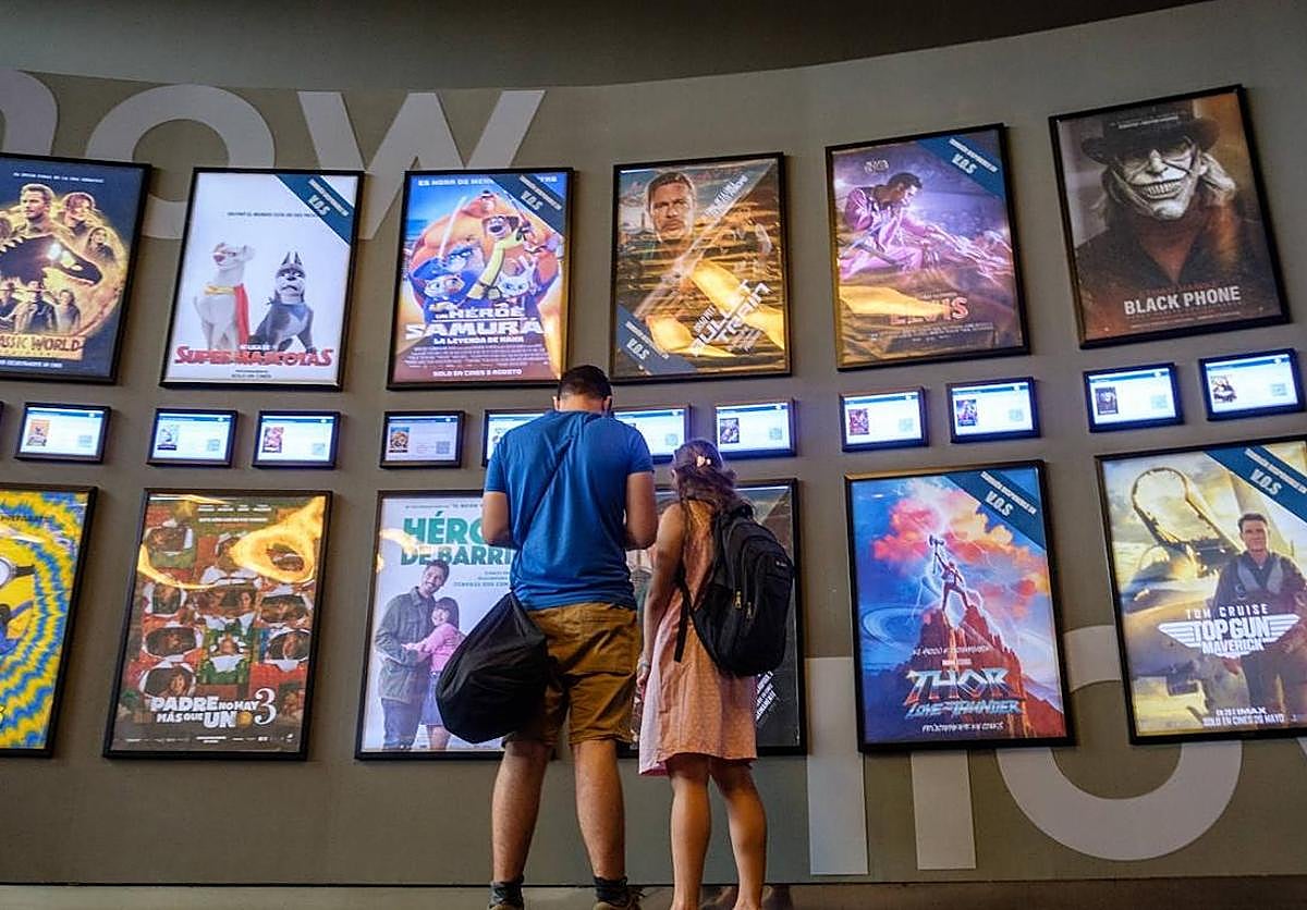 Una pareja contempla la cartelera de los cines Kinépolis