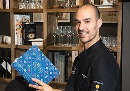 Samuel Hernández con un libro de cocina francesa en su restaurante.