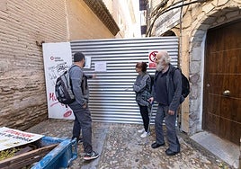 Mikel, Úrsula y Pedro, con su muleta, ante la valla que impide el paso por la calle Santa Ana desde hace casi seis meses.