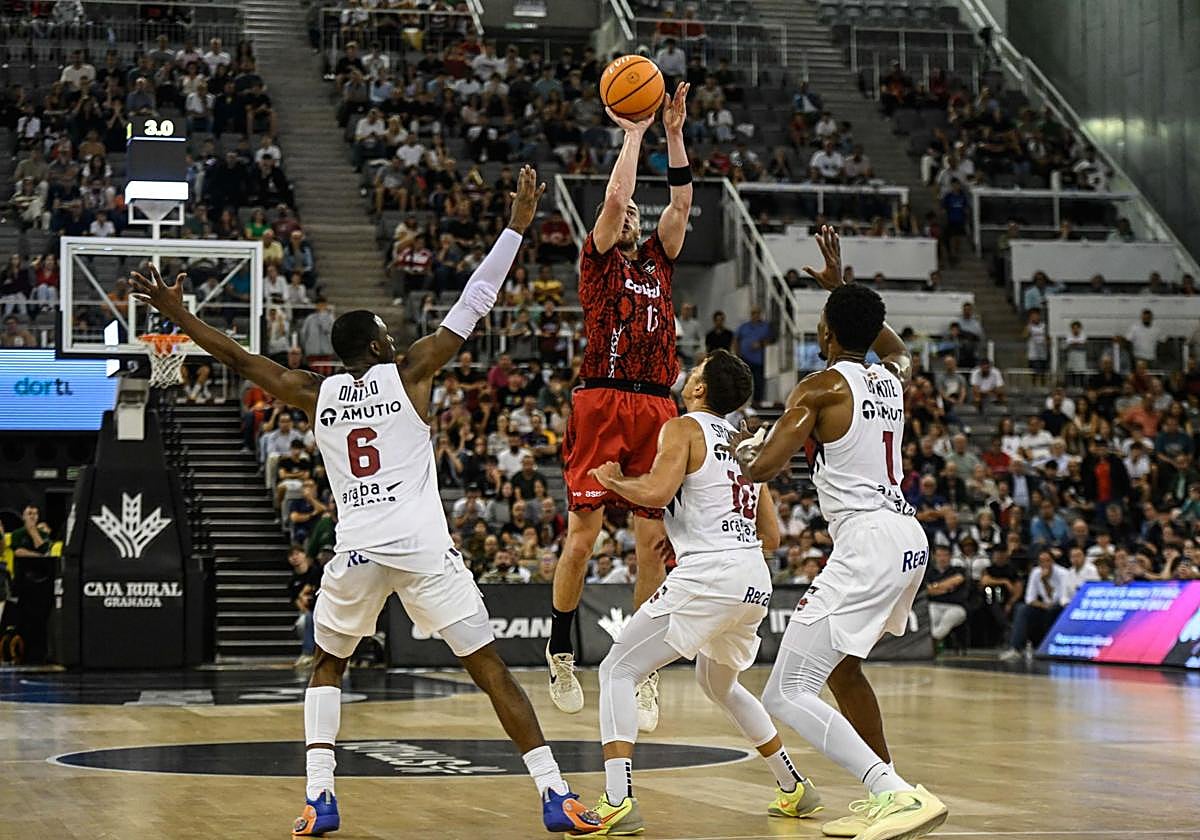 Matt Thomas, súper vigilado, se eleva para tirar un triple ante tres defensores del Baskonia.