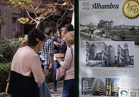 Una mujer observa uno de los carteles de la exposición de Cervezas Alhambra.