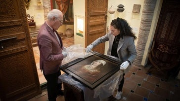 Carlos Ballesta y María Esperanza Pérez desenvuelven el cuadro de Isabel la Católica que ha adquirido la Fundación.