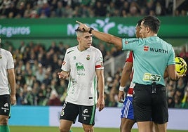 El colegiado Saúl Ais señala una falta durante el partido del Granada en Santander.