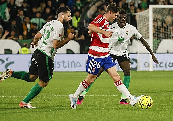 Sergio Ruiz conduce un balón entre futbolistas del Racing.