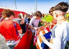 Pablo Sáenz firma una bandera a un aficionado.