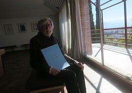 José García Román, ante la ventana del Aula Rosa Sabater del Auditorio Falla, con la partitura de su obra.