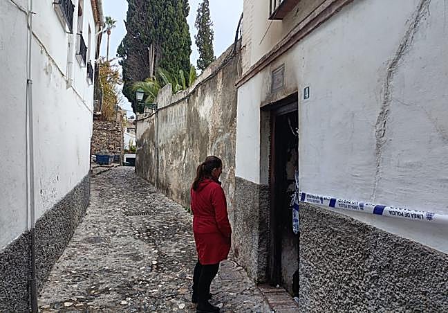 La presidenta de la asociación de vecinos del Albaicín, frente a la puerta completamente quemada del carmen de Aynadamar.