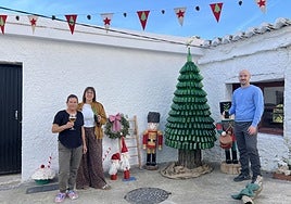 Ana y su familia posan junto al novedoso árbol fabricado con cervezas Alhambra,