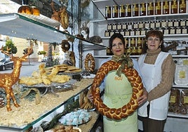 La dependienta Agustina Acuyo con una rosca de aceite navideña, junto a la propietaria, Paqui Macías, en su despacho de Cádiar.