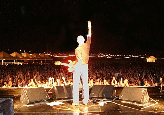 Jorge Martínez, guitarra en mano y brazo en alto, saluda a los asistentes al Zaidín Rock de 2024.