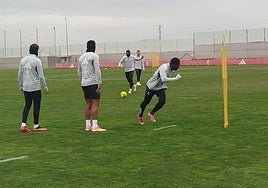 Sergio Ruiz, muy abrigado, da un pase durante un circuito con balón.