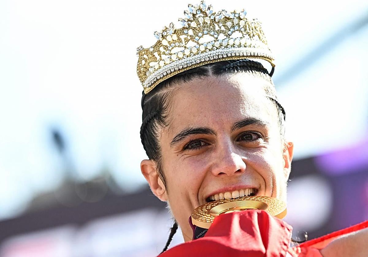 María Pérez muerde su nueva medalla de oro con la corona de la madre de Palmisano.