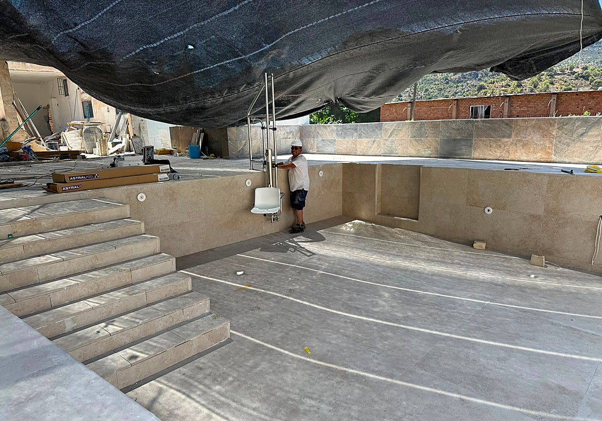 Un operario trabaja en el vaso de la futura piscina de Los Guájares.