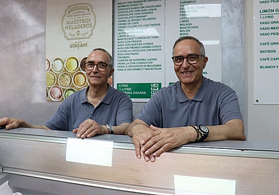 Los gemelos de la heladería Santa Teresa posan junto a su vitrina de helados.