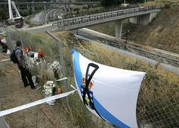 Una bandera de Galicia con un crespón negro ondea junto a la vía. / Efe