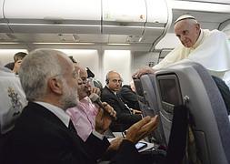 Francisco escucha la pregunta de uno de los periodistas en el avión que le traslada a Italia. / Luca Zennaro (Efe)