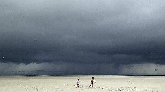 Dos niños escapan de la tormenta. 