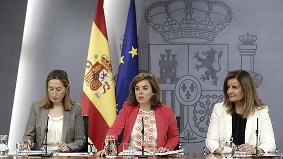 Sáenz de Santamaría (c), Fátima Báñez (d), y Ana Pastor (i), durante la rueda de prensa