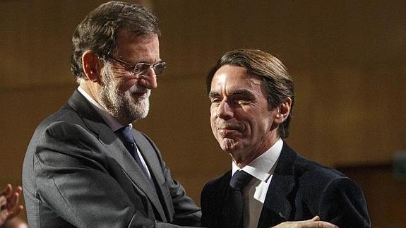 Rajoy y Aznar se saludan.