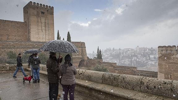 Turistas visitan la Alhambra durante una nevada.