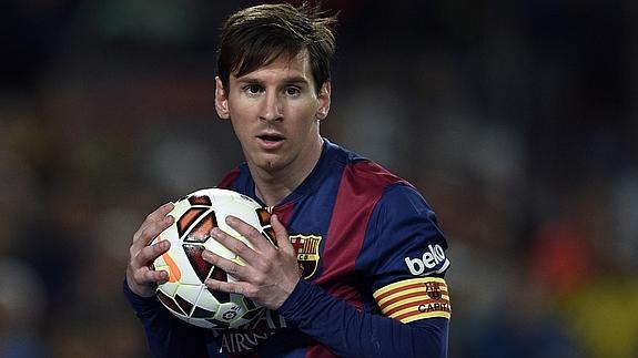 Messi agarra el balón.