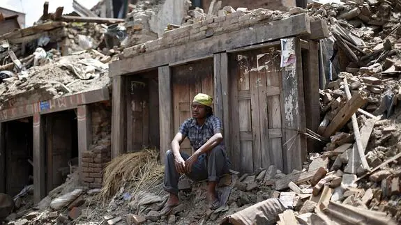 Un hombre descansa sobre los escombros un día después del último terremoto en Nepal. 