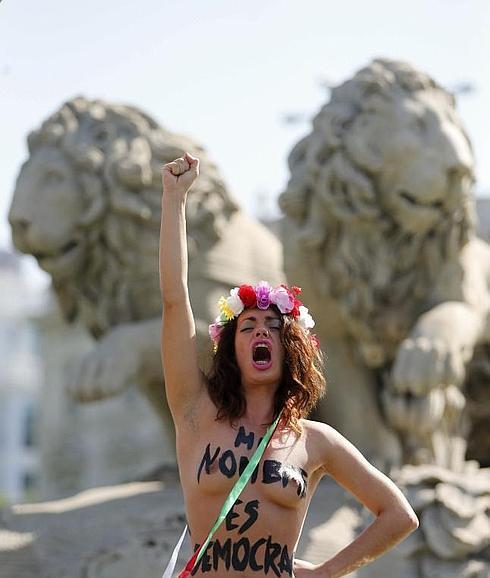 Una activista de Femen, encaramada a la fuente de la Cibeles. 