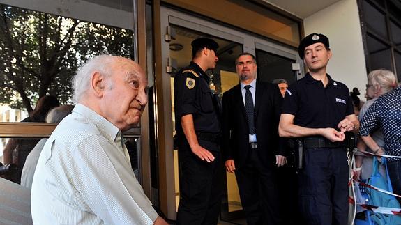Un pensionista griego espera a las puertas de un banco de Atenas.