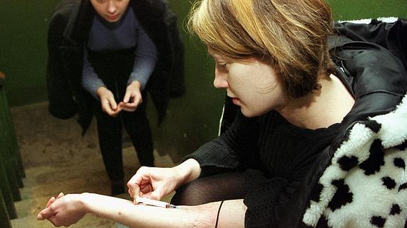 Una joven inyectándose heroína. 